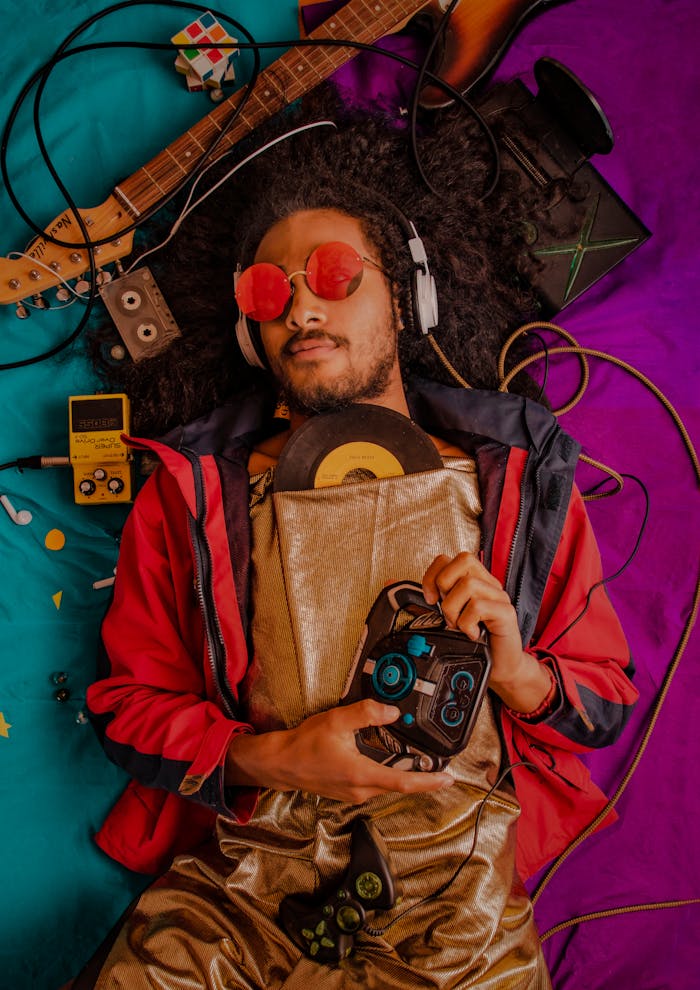 Man with afro and headphones enjoying retro music surrounded by vintage items.